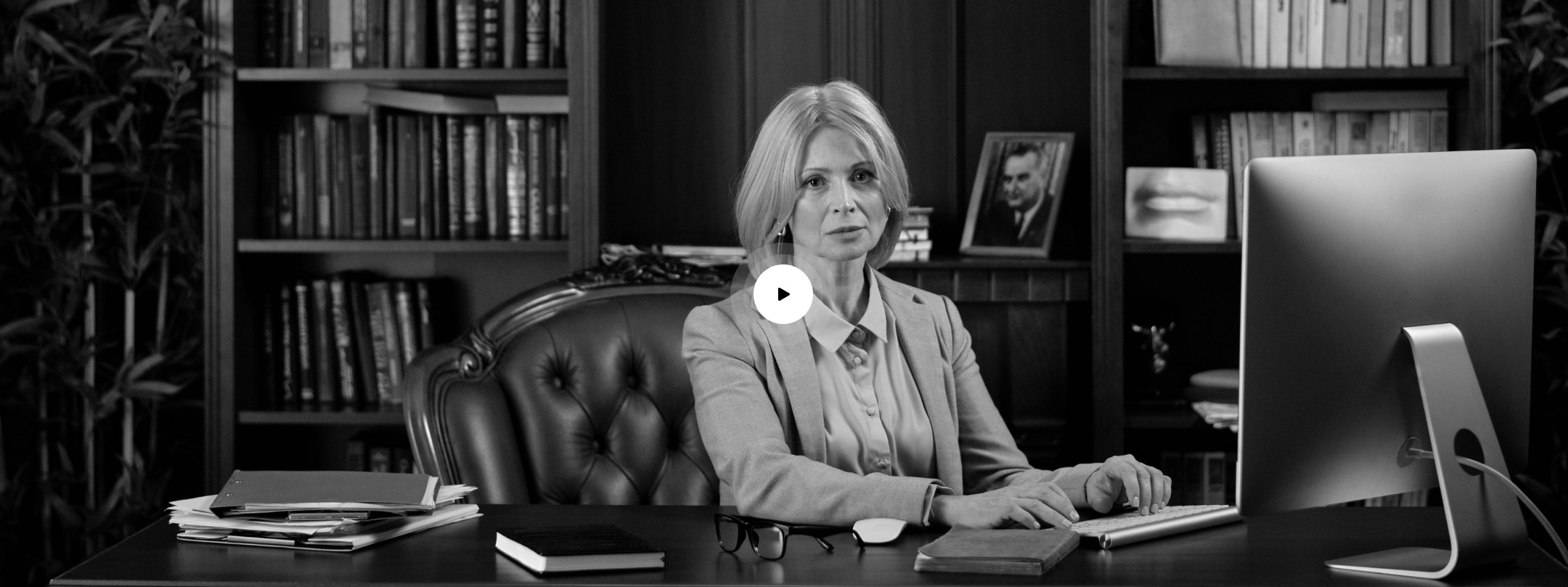 An attorney at her desk in a wood panelled office lined with law books